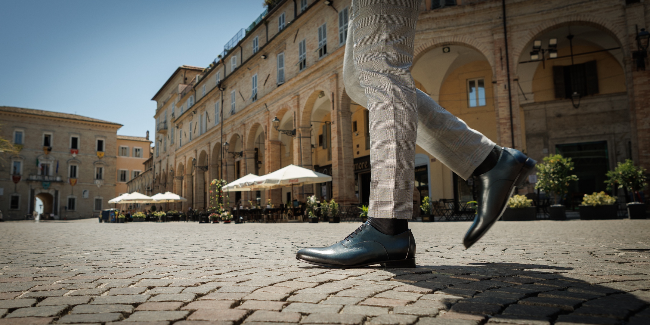 Nunzio Orsini dark blue Oxford shoes worn on cobblestone piazza in Marche, Italy